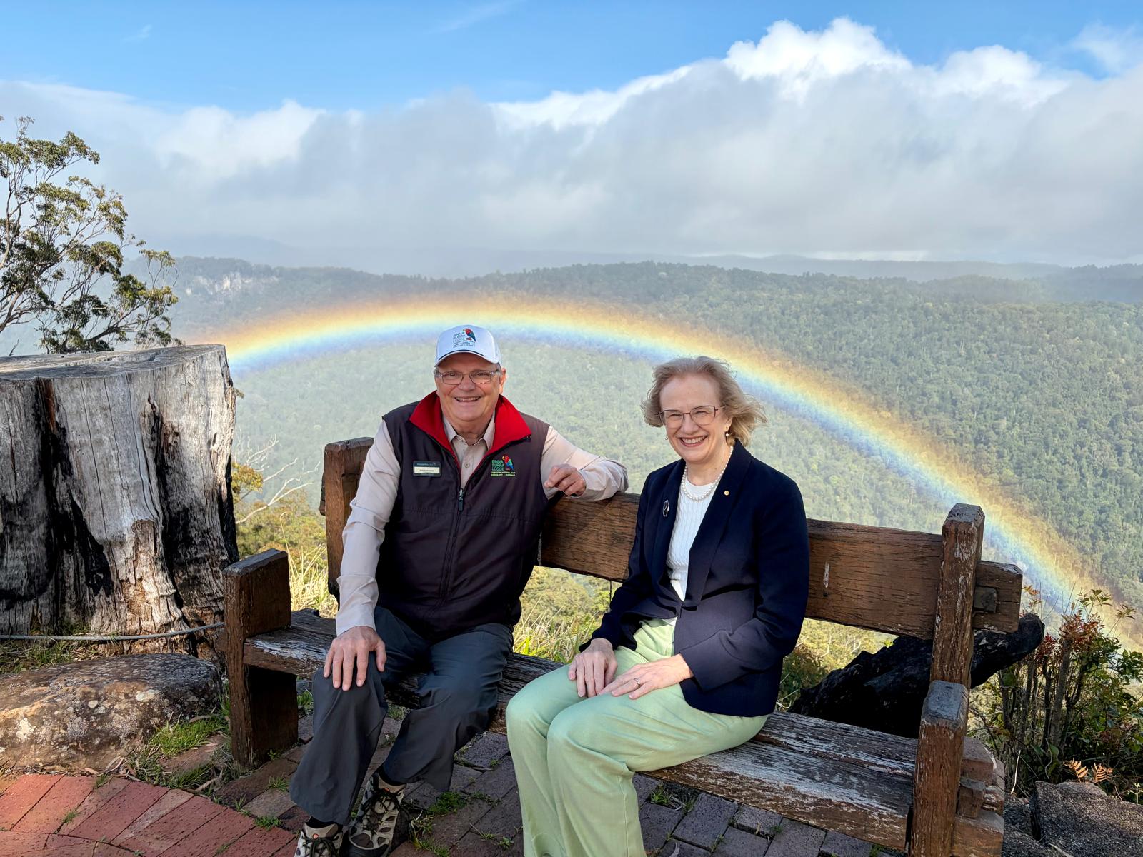Image shows Binna Burra Chair, Steve Noakes with QLD Governor Jeannette Young at Coomera Terrace with a rainbow in the background